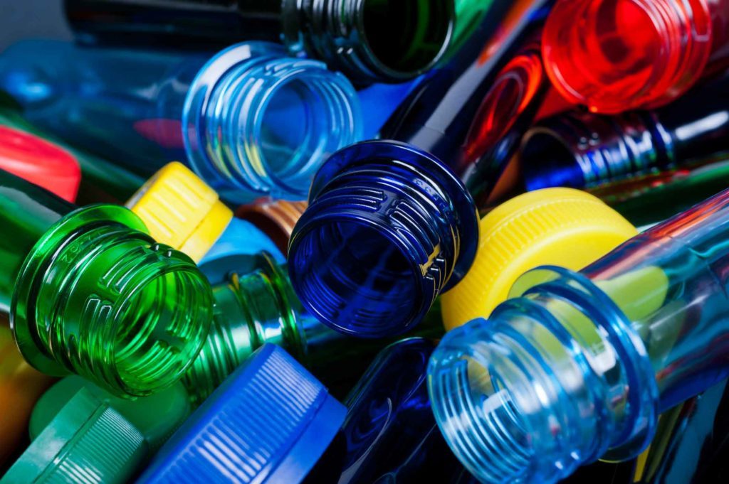 Amoncellement de bouteilles d'eau de toutes les couleurs en plastique