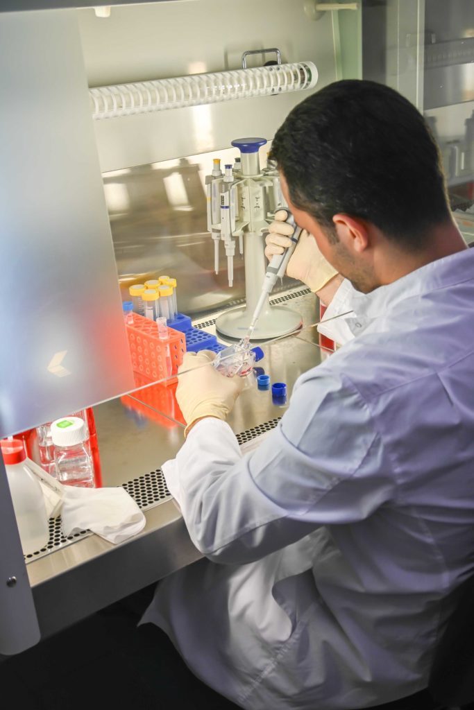 Scientifique qui fait un diagnostic in vitro de cultures cellulaires dans un laboratoire