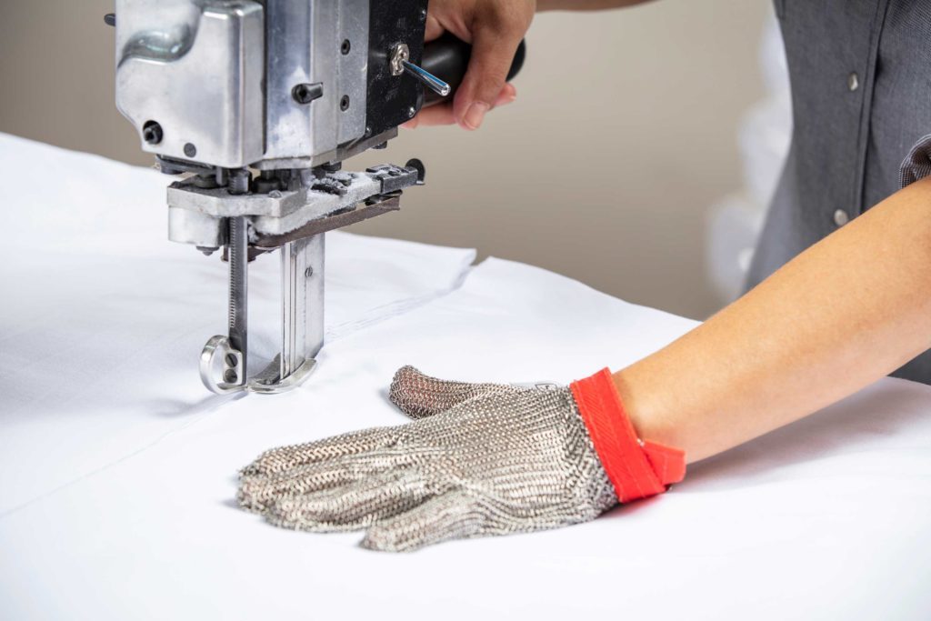 Une couturière industrielle avec un gant de protection