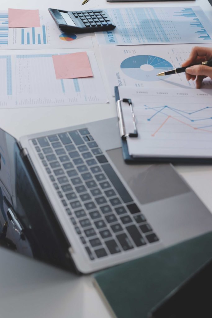 Bureau avec un ordinateur et des feuilles avec des graphiques dessus