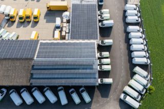 centre logistique avec des panneaux solaires sur le toit et un parking de camions à côté