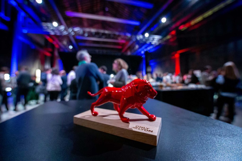 Statue du Lyon rouge d'OnlyLyon posé sur un meuble durant un salon